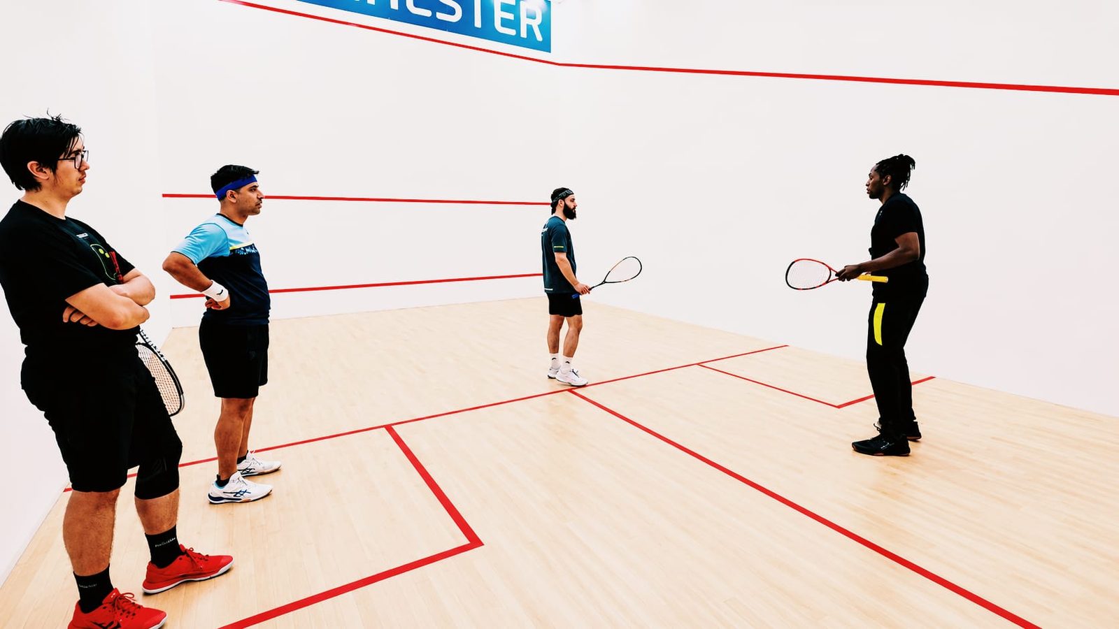 Players training together on court at Manchester Squash