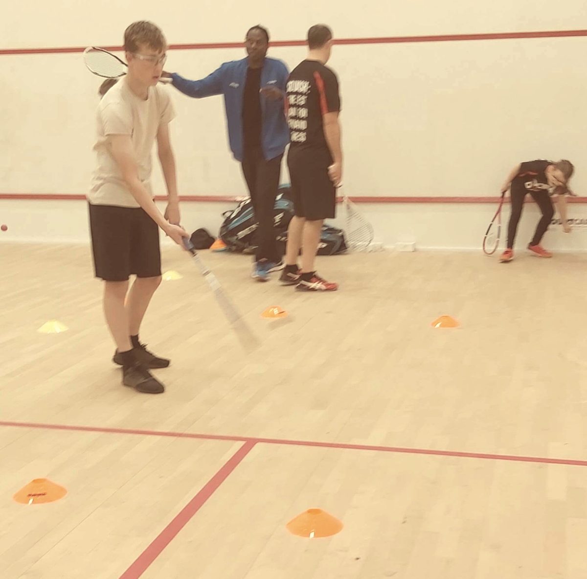 Mas coaching junior players on court